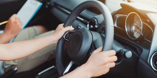 Driving instructor demonstrating the correct hand position on the steering wheel