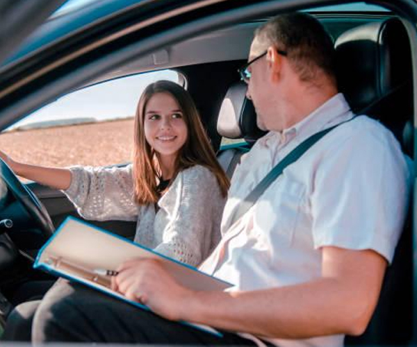 Driving instructor calmly assisting a nervous student during a city driving lesson